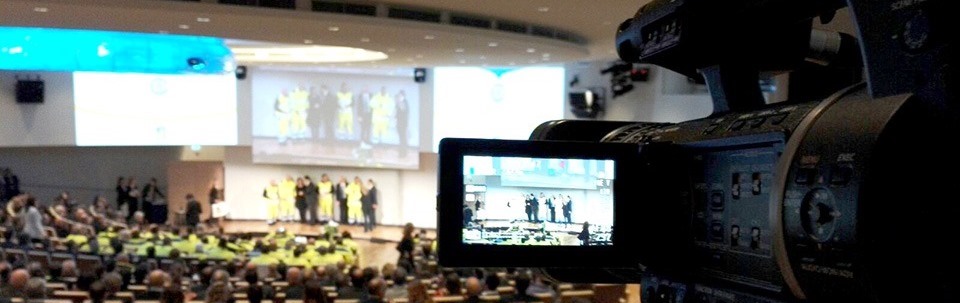 Immagine di una telecamera che riprende il palco di un evento